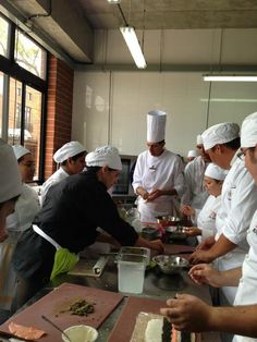 a group of chefs preparing food in a kitchen