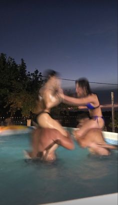 three people in a swimming pool playing with each other