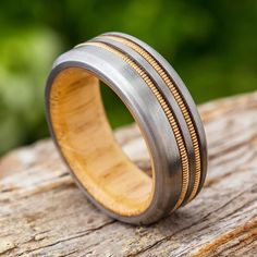 a wooden and metal ring sitting on top of a piece of wood