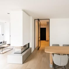 an empty living room with white walls and wood flooring is seen in this image