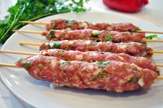 meat skewers on a white plate with parsley