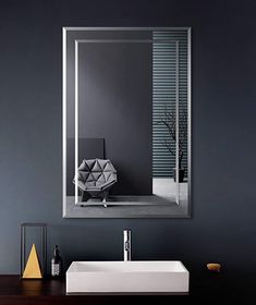 a bathroom sink sitting under a mirror in front of a wall mounted faucet