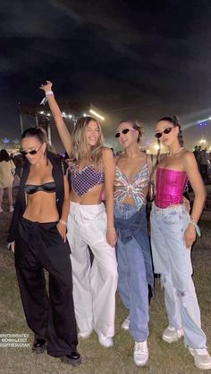 three women standing next to each other at a music festival