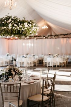 the tables are set with white linens and floral centerpieces for an elegant wedding reception