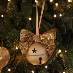 a christmas ornament hanging from a tree with lights in the background and a star on it