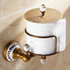 a gold and white toilet paper holder on the wall