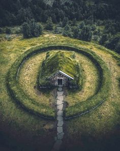 an aerial view of a house in the middle of a grassy field with a spiral design