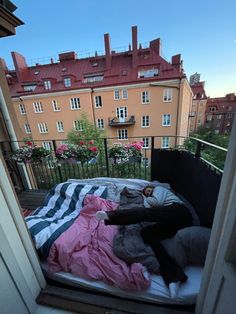 a person laying on top of a bed next to a building