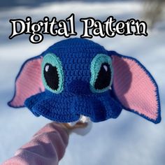 a crocheted elephant hat with big eyes on it's head is shown in the snow