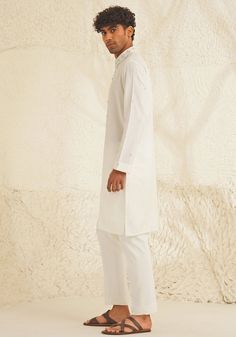 Presenting an exquisite Porcelain White Silk Kurta Set, featuring a sophisticated Chinese collar, elegant metallic silver buttons, and intricate hand-embroidered detailing on the neckline and sleeves. Paired with trendy white pants, this ensemble is perfect for engagements, Roka ceremonies, or puja events, combining timeless elegance with contemporary style. Composition : Dupion Silk Care: Dry Clean Only and Vacuum Storage This product can be customized for sleeves, length and colour Delivery : 4-6 weeks as the product is hand crafted. Check Size Guide or choose MySize for free customisation (All Sizes above XL can be made at 15% additional cost) For more information and sizes please contact fabiliciousfashion@gmail.com or visit our Copenhagen studio. About the Designer : Shreyansh, a dist Silk Kurta Set, Chinese Collar, Vacuum Storage, Indian Wedding Wear, Silk Kurta, Dupion Silk, Silver Buttons, Kurta Set, White Silk