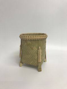 a small basket with handles on the bottom is sitting in front of a white background