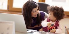 a woman and child looking at a laptop screen