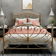 a gold bed with pink and white sheets in a gray room next to two lamps