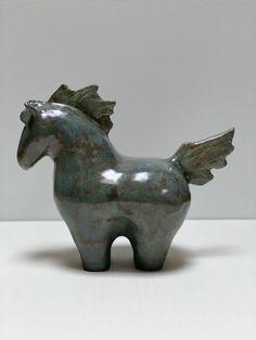 a metal horse statue sitting on top of a table