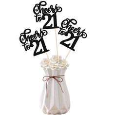 a white vase filled with flowers and two black numbers on top of each number one