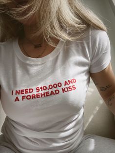 i think we all just need 10k and a little forehead kiss. PRINTED ON A FITTED WOMENS TEE - go for your regular size for a form fitting look and size up if you like a looser fitted tee.  white tee with red ink. black tee with white ink.  TEES: - 100% ringspun cotton -- extra soft & lightweight - women's fit, true to size CARE INSTRUCTIONS: - machine wash cold with like colors - tumble dry low or hang to dry Women's T-shirts, T Shirt Words Ideas, Print T-shirts, Clothes You Need, T-shirt Prints, Washing Machine Aesthetic, Forehead Kiss, Y2k T Shirts, How To Have Style