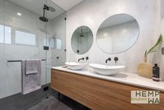 a bathroom with two sinks and mirrors on the wall