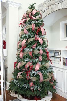 a christmas tree decorated with red, white and green ribbons