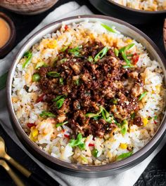 a bowl filled with rice and meat on top of a table