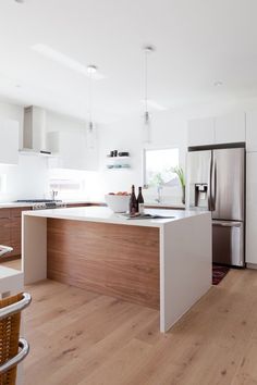 a kitchen with white cabinets and wood flooring