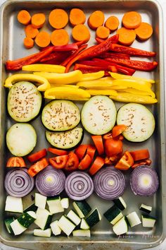 an assortment of vegetables in a tray ready to be cut and put into the oven