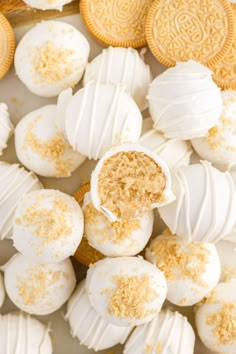 white and gold desserts are arranged on a plate with cookie cookies in the background