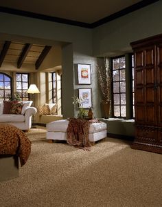 a living room filled with furniture and windows next to a dresser in front of a window