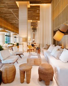 a living room filled with lots of white furniture and decor on top of carpeted flooring