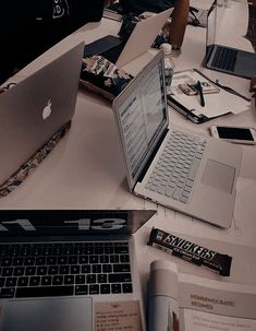 several open laptops sitting on top of a white table next to papers and pens