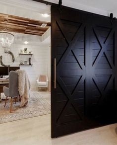 a living room filled with furniture next to a wooden door that has an x design on it