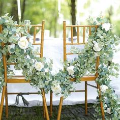 the chairs are decorated with flowers and greenery