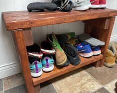 several pairs of shoes are lined up on a wooden shelf in front of a wall