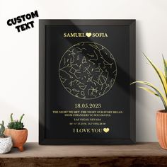 a black framed poster with gold foil stars on it next to a potted plant