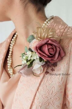 a close up of a woman wearing a pink dress with a flower on it's lapel