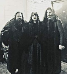 an old photo of three people dressed in medieval clothing, standing next to each other