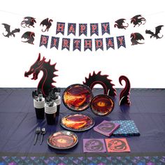 a table topped with plates and cups filled with cake next to a sign that says happy birthday