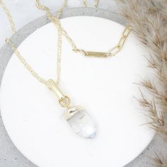 The Stunning LQ Crystal Quartz Necklace is the perfect accessory to elevate any outfit. A long, delicate chain that drapes elegantly around the neck and is accented with a glamorous crystal quartz pendant. Quartz is said to promote healing and balance, making it a great addition to your daily routine. The LQ Necklace is made with gold filled materials, giving it a luxurious and high-end look. Perfect for dressing up or down, and makes a great gift for any occasion. Add a touch of elegance and po Spiritual Gold Crystal Necklaces For Layering, Gold Gemstone Crystal Necklace For Layering, Gold Quartz Crystal Necklace As Gift, Gold Quartz Necklace With Spiritual Style, Clear Quartz Necklace For Gift, Gold Nickel-free Crystal Necklace For Gifts, Crystal Quartz Necklace, Elegant 14k Gold-filled Crystal Necklace Gift, Quartz Crystal Pendant