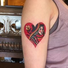 a woman with a heart shaped tattoo on her arm