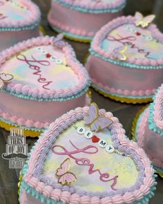 several decorated heart shaped cakes sitting on top of a table