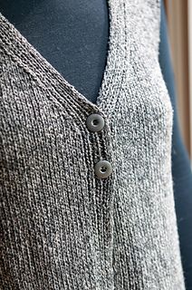 a woman's gray sweater with buttons on the front and back, next to a mannequin torso