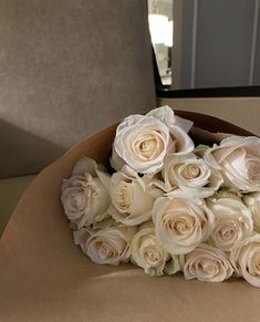 a bouquet of white roses sitting on top of a table