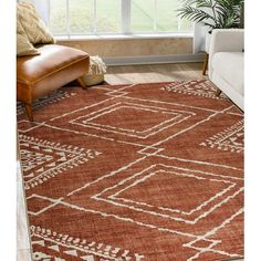 a brown and white rug in front of a window with a chair next to it