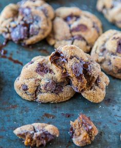 chocolate chip cookies on a baking sheet with one broken in half and the other partially eaten