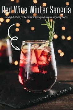 red wine winter sangria with rosemary garnish in a glass on a table