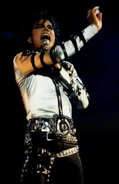 michael jackson performing on stage with his hands in the air