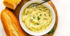 a bowl of hummus next to two pieces of bread