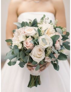 a bridal holding a bouquet of white and pink flowers