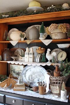 an old china cabinet is filled with dishes and other things to decorate for the holiday season