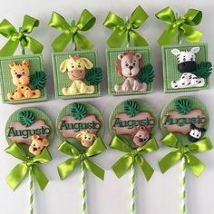 there are many cupcakes that have animals on them and ribbons around them with green bows