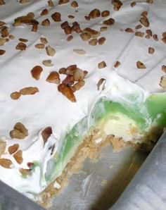 a cake with white frosting and nuts on top